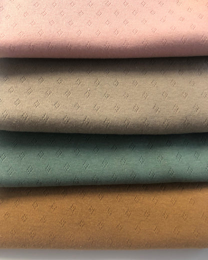 Nahaufnahme von Ajour Jersey Stoff mit Pointoille-Struktur in Pastellfarben